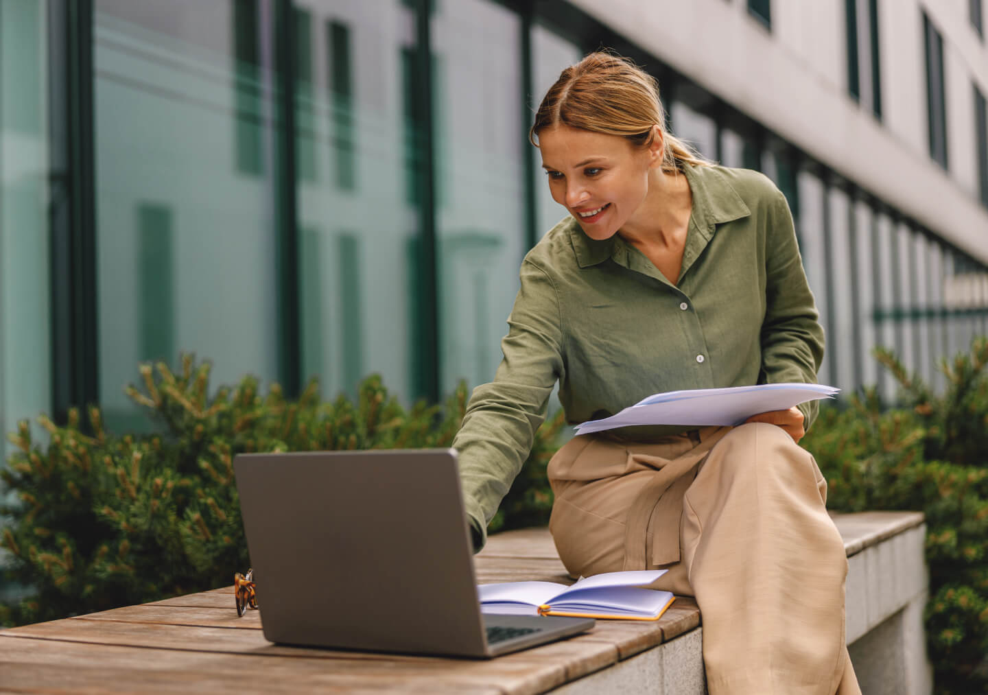 A person sitting on a bench with a computer